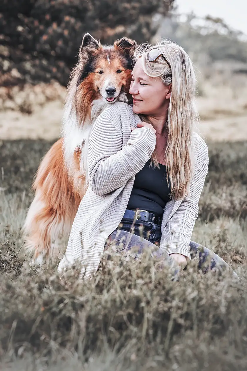 Collie schaut über die Schulter der Hundehalterin