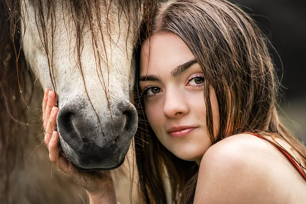 Close up von einem Mädchen, dass für ein Pferdeshooting mit einem Pony posiert